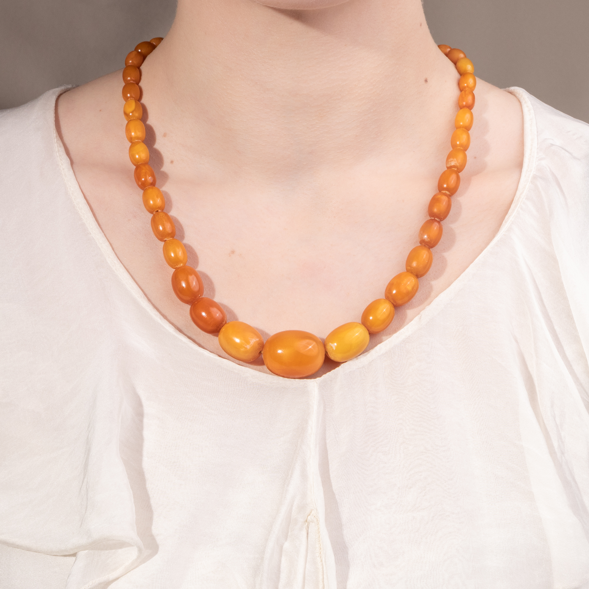 Antikes Collier aus „Butterscotch“- Bernstein in Olivenform, um 1930 Antikes Collier aus „Butterscotch“- Bernstein in Olivenform, um 1930